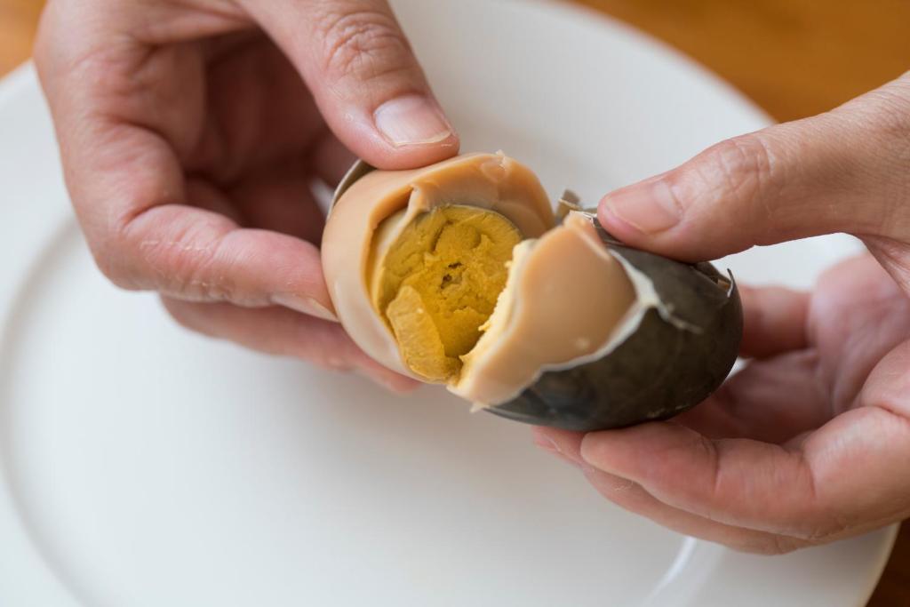 une personne détenant une aubergine babeurre dans l'établissement Jyokiya, à Unzen