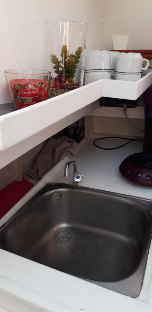 - un évier dans une cuisine avec une étagère au-dessus dans l'établissement Le Nid sur l'Eau, à Sète