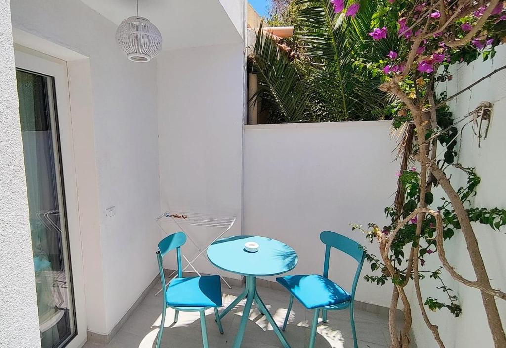 une table et des chaises dans une pièce avec des fleurs dans l'établissement Luagos club Resort, à Lampedusa