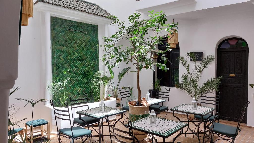 un patio avec tables, chaises et plantes dans l'établissement Riad Cosy, à Marrakech