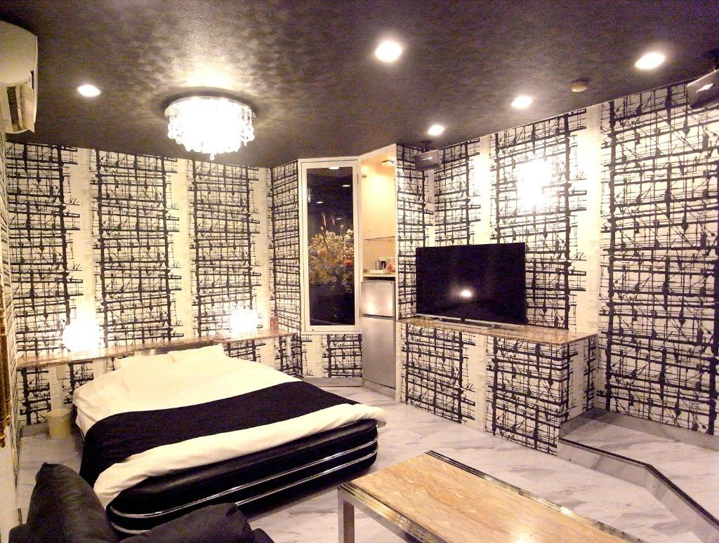 une chambre avec un lit et une télévision dans l'établissement ホテル暴れ狸の鬼袋姫路駅前店 男塾ホテルグループ, à Himeji