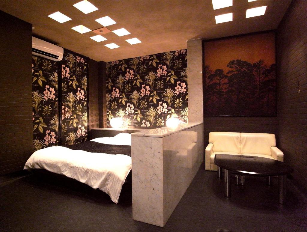 une chambre avec un lit, un bureau et une chaise dans l'établissement ホテル暴れ狸の鬼袋姫路駅前店 男塾ホテルグループ, à Himeji