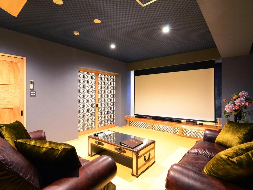 un salon avec des canapés et un grand écran de projection dans l'établissement 日本旅館 器 別府鉄輪 nihonryokan utsuwa beppukannnawa, à Beppu 69 autres photos