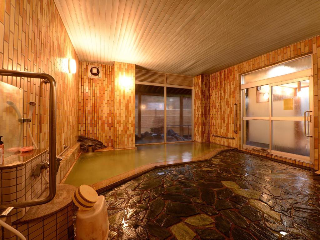 Cette chambre dispose d'une salle de bains avec une piscine d'eau. dans l'établissement 蓬平温泉 蓬莱館 福引屋, à Nagaoka