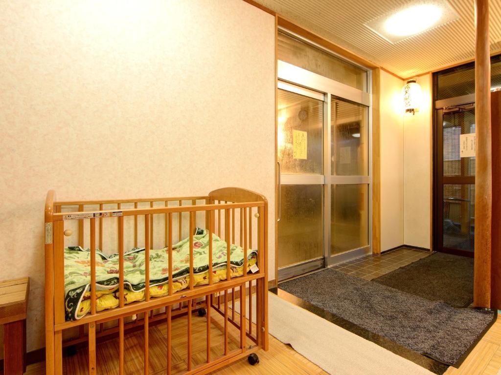 un berceau dans le coin d'une pièce dans l'établissement 蓬平温泉 蓬莱館 福引屋, à Nagaoka