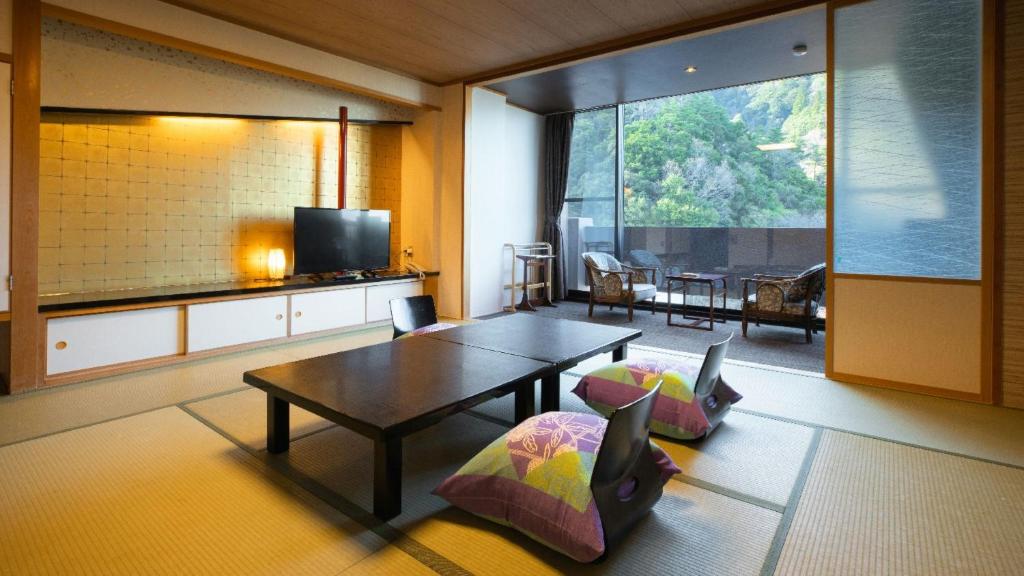 un salon avec une table et une grande fenêtre dans l'établissement Hotel Yunomoto, à Komono