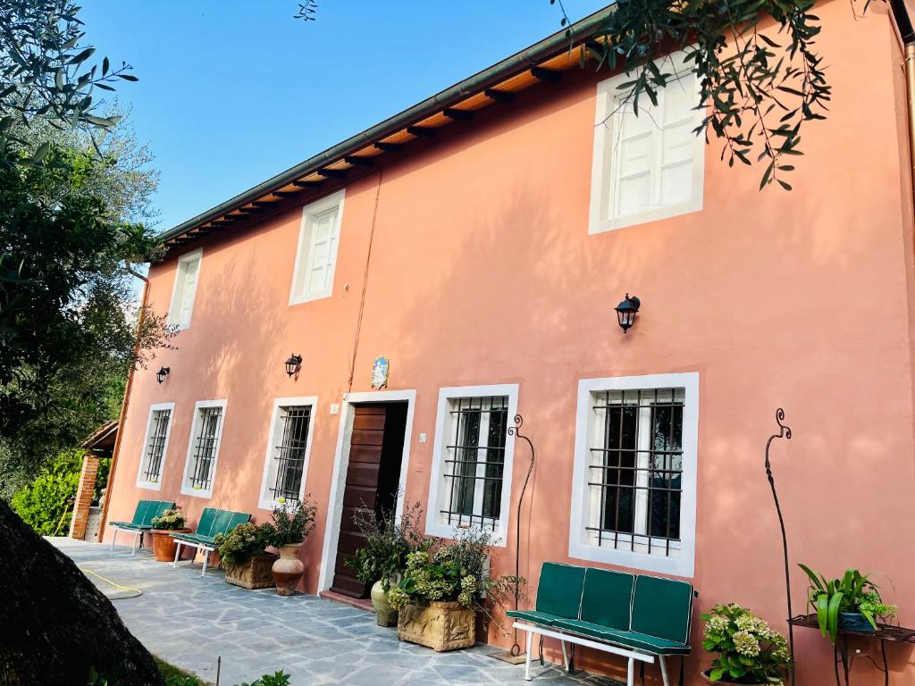 Un bâtiment orange avec des bancs devant lui dans l'établissement Podere Il Piantoneto, à Stiava