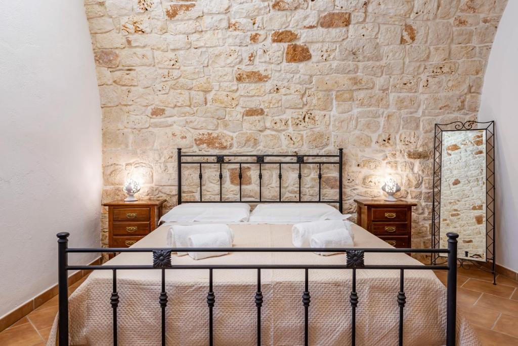 une chambre avec un lit et un mur en pierre dans l'établissement Masseria Pitorrè with private pool, à Conversano 25 autres photos