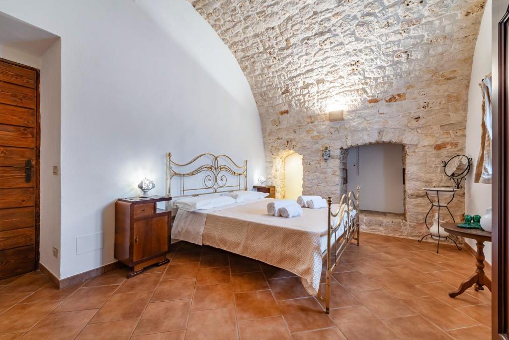 une chambre avec un lit et un mur de briques dans l'établissement Masseria Pitorrè with private pool, à Conversano