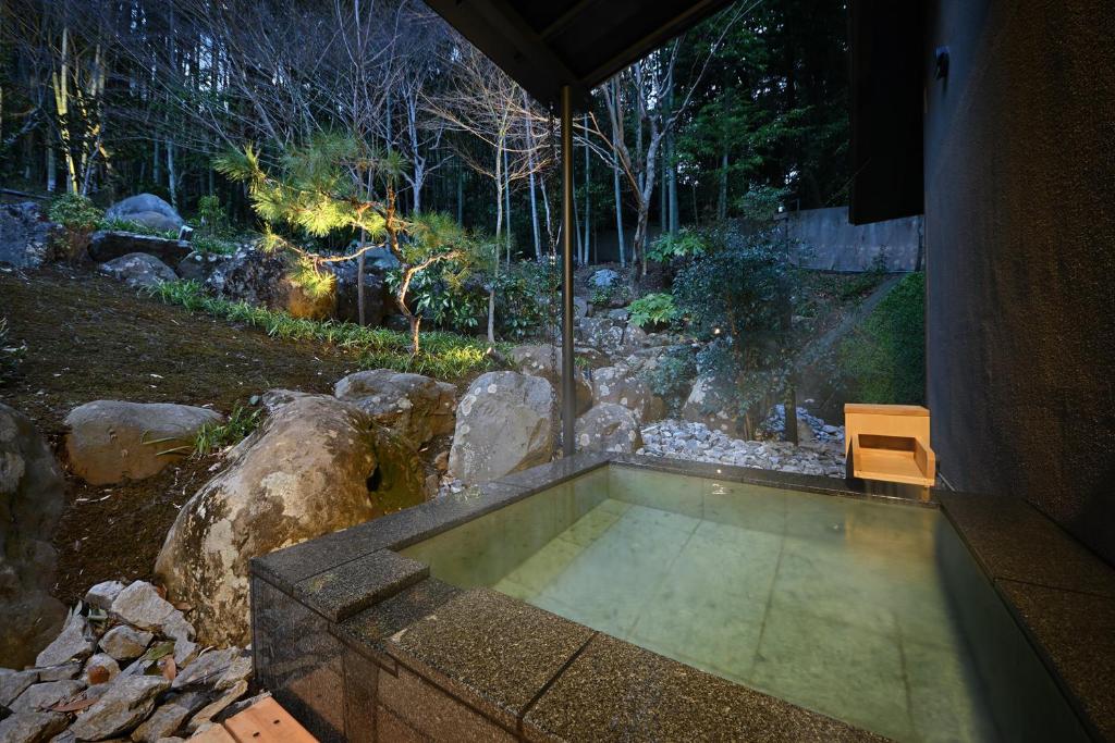 - une petite piscine dans une cour avec un banc dans l'établissement Oni no Sumika, à Izu