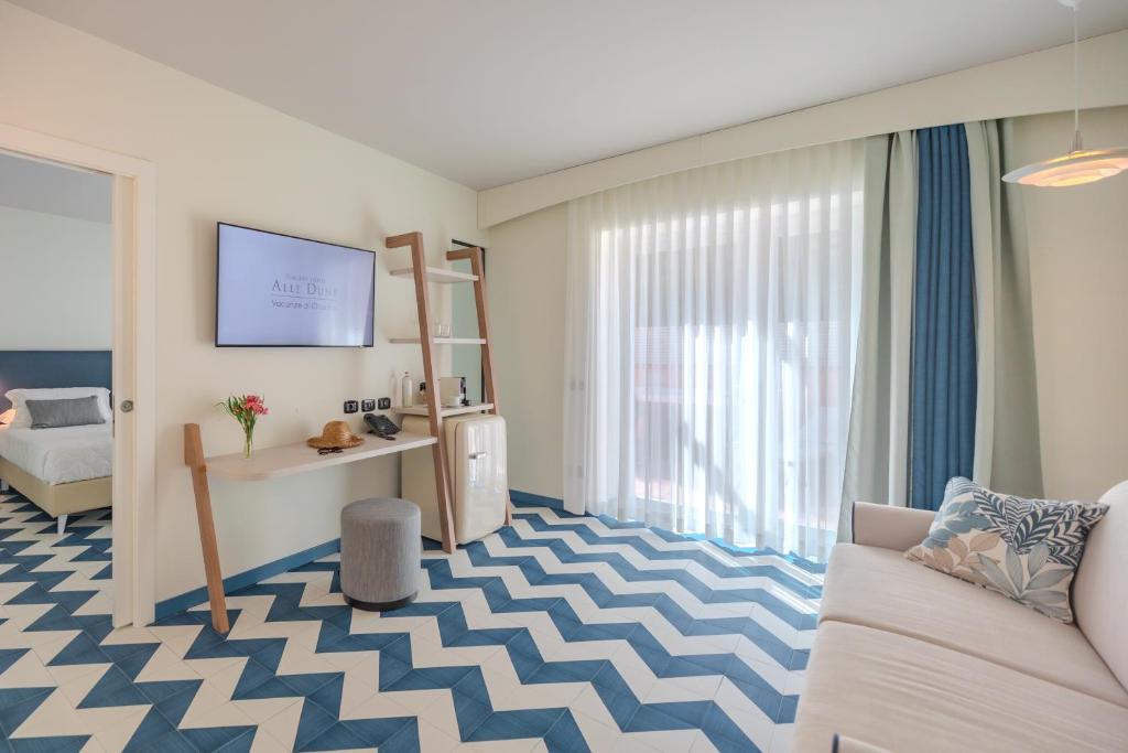 un salon avec un canapé et une table dans l'établissement Tuscany Hotel Alle Dune, à Marina di Castagneto Carducci