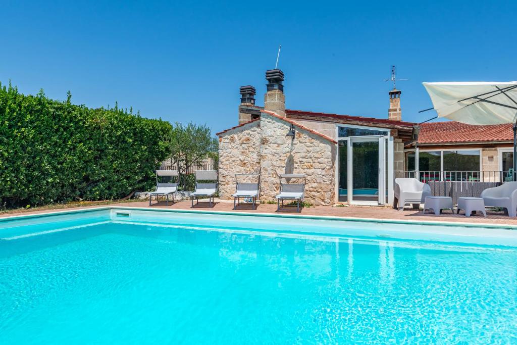 une piscine devant une maison dans l'établissement Masseria Pitorrè with private pool, à Conversano