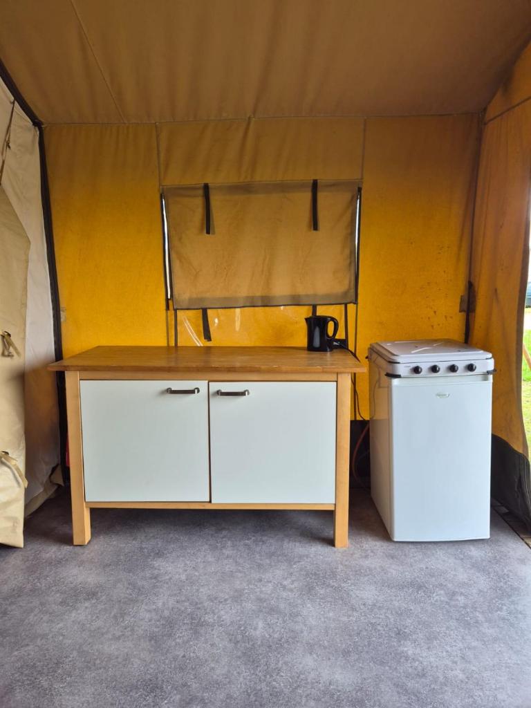 une table et un lave-linge dans une tente dans l'établissement La Bedure, à Luzy