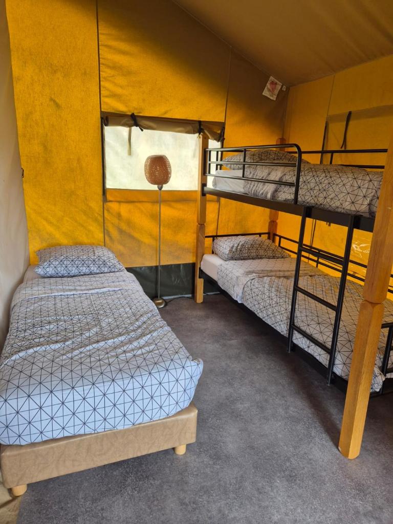 Ce lit superposé se trouve dans un dortoir doté d'un mur jaune. dans l'établissement La Bedure, à Luzy