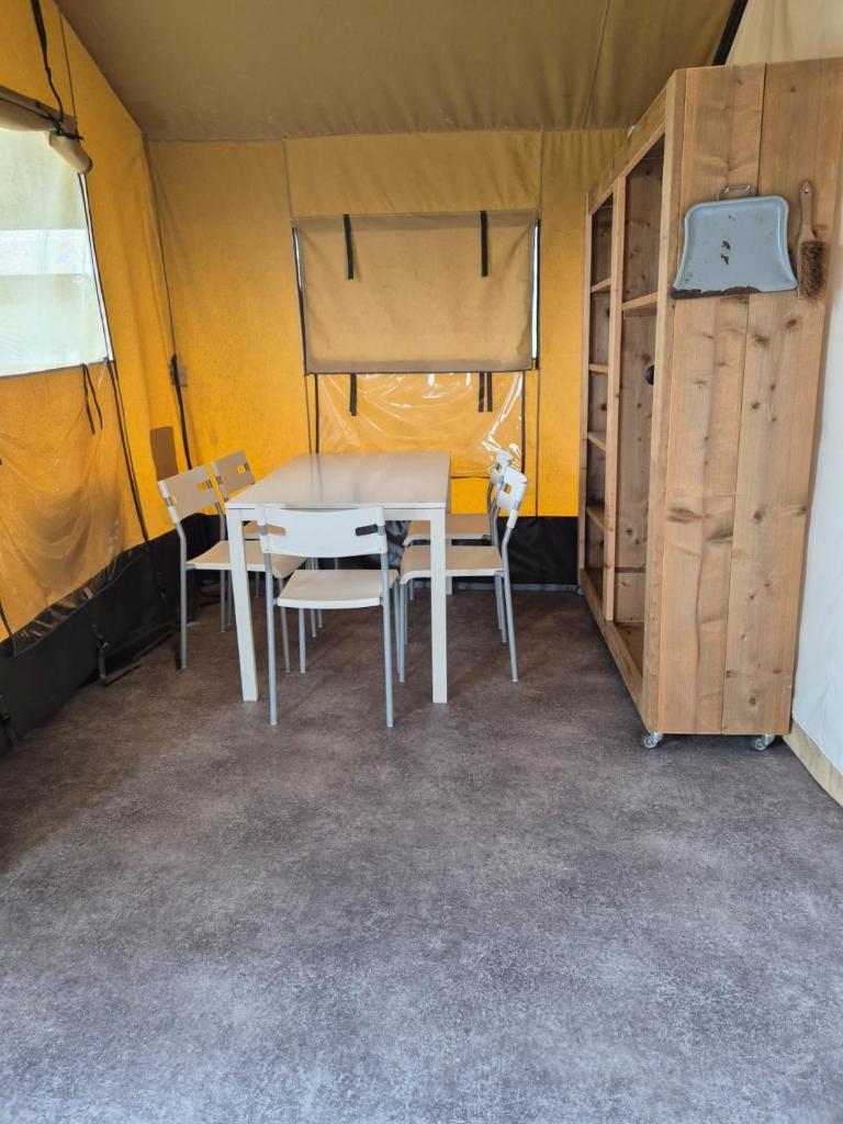 - une table à manger et des chaises dans une tente dans l'établissement La Bedure, à Luzy