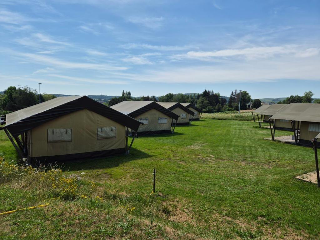 une rangée de tentes dans un champ d'herbe dans l'établissement La Bedure, à Luzy