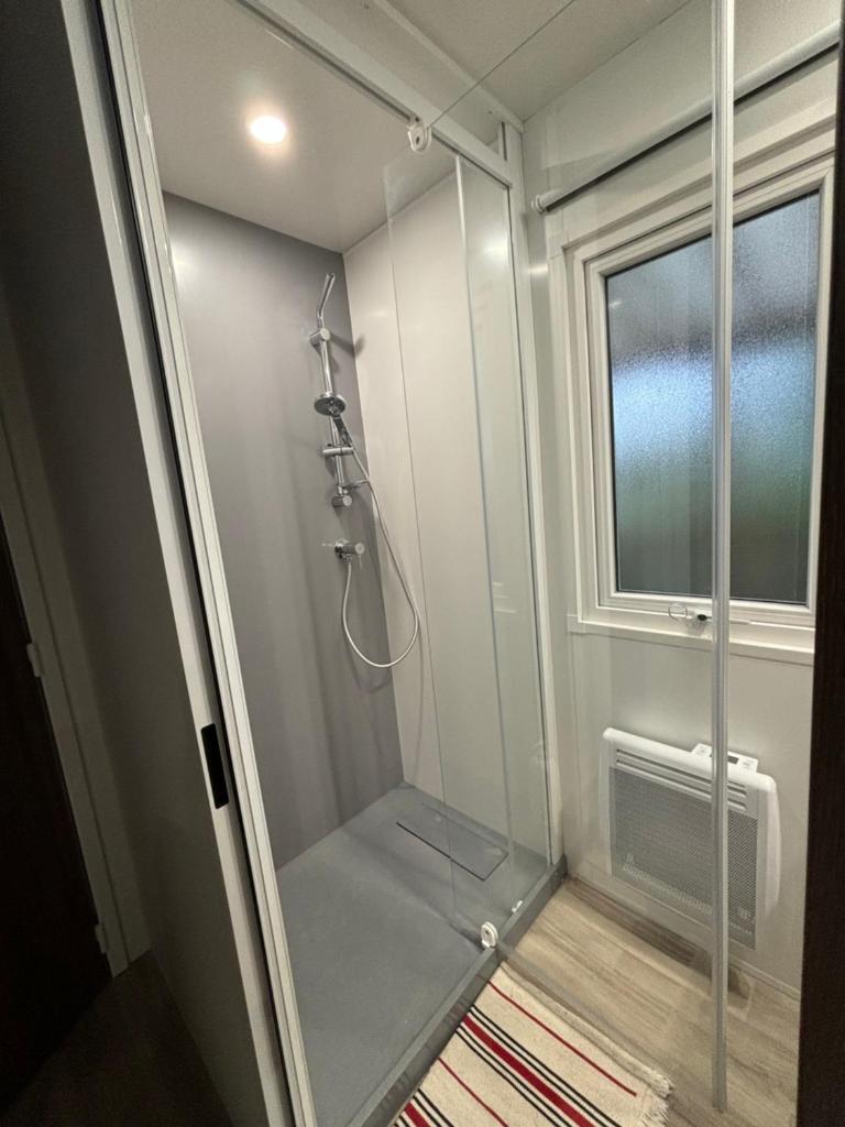 La salle de bains est pourvue d'une douche à l'italienne et d'une fenêtre. dans l'établissement Mobil home 253 Camping La Réserve 4 étoiles à Gastes, à Gastes