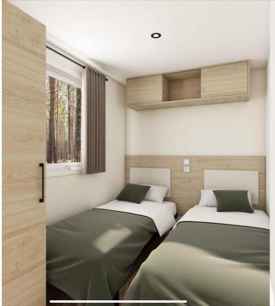 deux lits dans une chambre avec une fenêtre dans l'établissement Bungalow Port Grimaud 177, à Grimaud