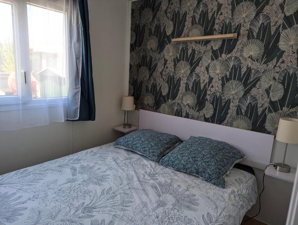 une chambre avec un lit avec deux oreillers dessus dans l'établissement Mobilhome avec piscine- plage à 10 minutes, à Saint-Aygulf