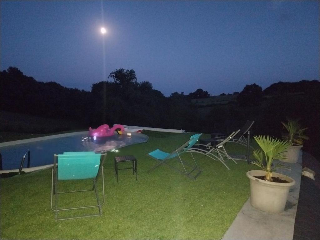 une arrière-cour avec une piscine la nuit dans l'établissement La Bubble, à La Salvetat-Peyralès