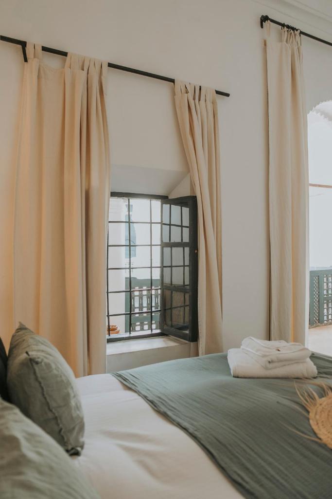 une chambre avec un lit et une grande fenêtre dans l'établissement Dar El Qadi, à Marrakech 37 autres photos