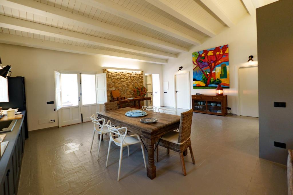 une cuisine et une salle à manger avec une table et des chaises en bois dans l'établissement Villa Ruya Cefalù, à Cefalù