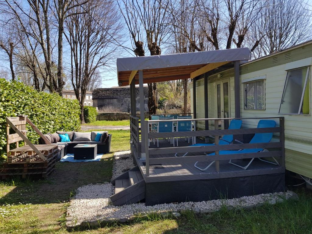 une caravane verte avec une terrasse couverte et un canapé dans l'établissement Gard mobilhome, à Saint-Ambroix