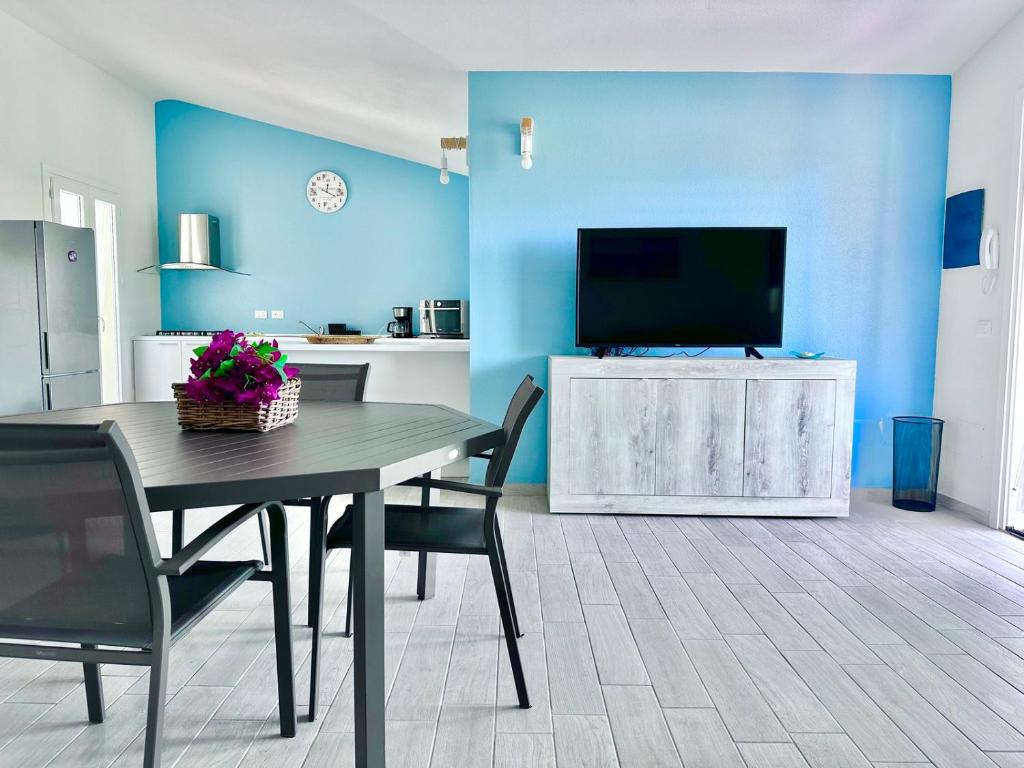 d'une salle à manger avec une table et une télévision à écran plat. dans l'établissement Villa Neni - Key to Villas, à Valledoria