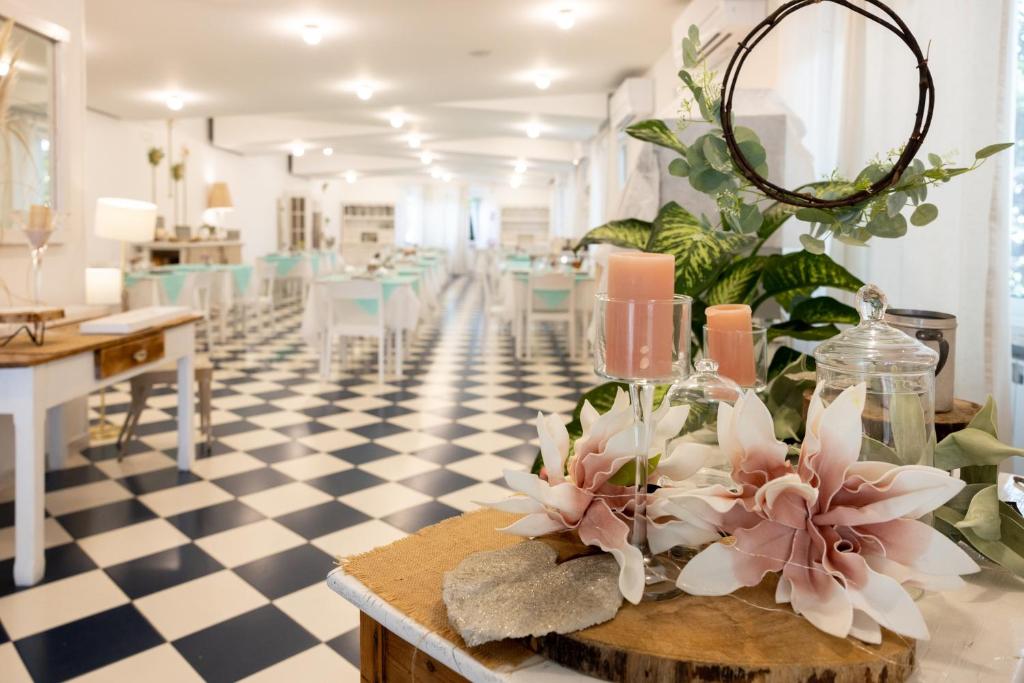 Cette chambre comprend une table avec des fleurs. dans l'établissement Hotel Petit, à Silvi Marina