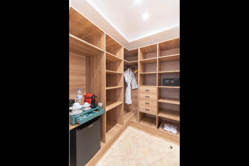 Elle comprend un dressing avec des étagères en bois et une cuisinière. dans l'établissement Riad Atlas Palace & SPA, à Marrakech