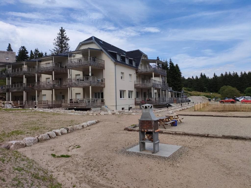 - un grand bâtiment avec une statue d'oiseau devant dans l'établissement bel appartement 3 pièces dans la Résidence Vosges-Alsace Orbey, à Orbey