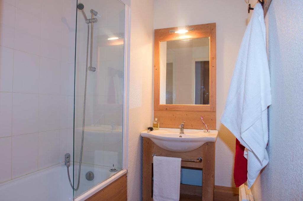 une salle de bain avec un lavabo, une douche et un miroir dans l'établissement Résidence Goélia Le Balcon des Neiges, à Saint-Sorlin-dʼArves