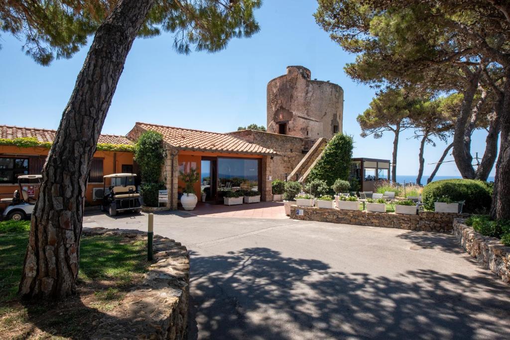 une maison avec un arbre devant dans l'établissement Boutique Hotel Torre Di Cala Piccola, à Porto Santo Stefano