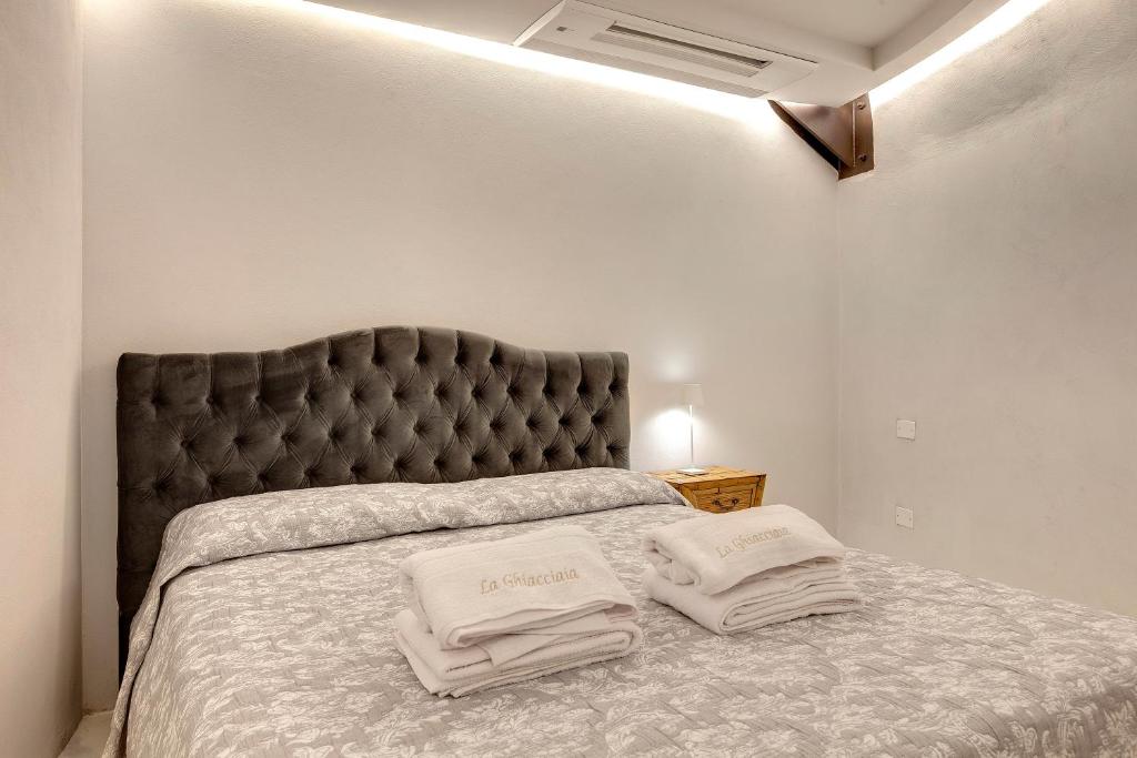 une chambre avec un grand lit avec deux oreillers dessus dans l'établissement La Ghiacciaia magica !, à Calenzano