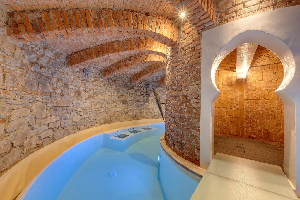 La salle de bains est pourvue d'une baignoire et d'un mur en briques. dans l'établissement La Ghiacciaia magica !, à Calenzano