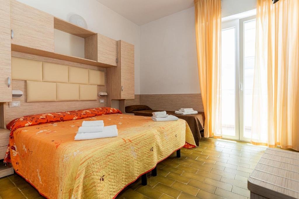 une chambre avec un grand lit et une grande fenêtre dans l'établissement Hotel Croce Del Sud, à Rimini 83 autres photos
