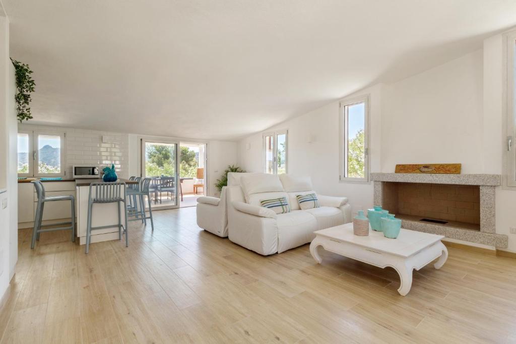 un salon avec un canapé blanc et une table dans l'établissement Villa Angelina con piscina e giardino privato a pochi passi dalla Spiaggia di Campus, à Villasimius