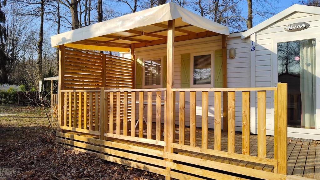 Ce chalet en bois dispose d'une terrasse couverte avec un toit. dans l'établissement 45mn de Paris Sympathique logement trois chambres - A76, à Saint-Chéron