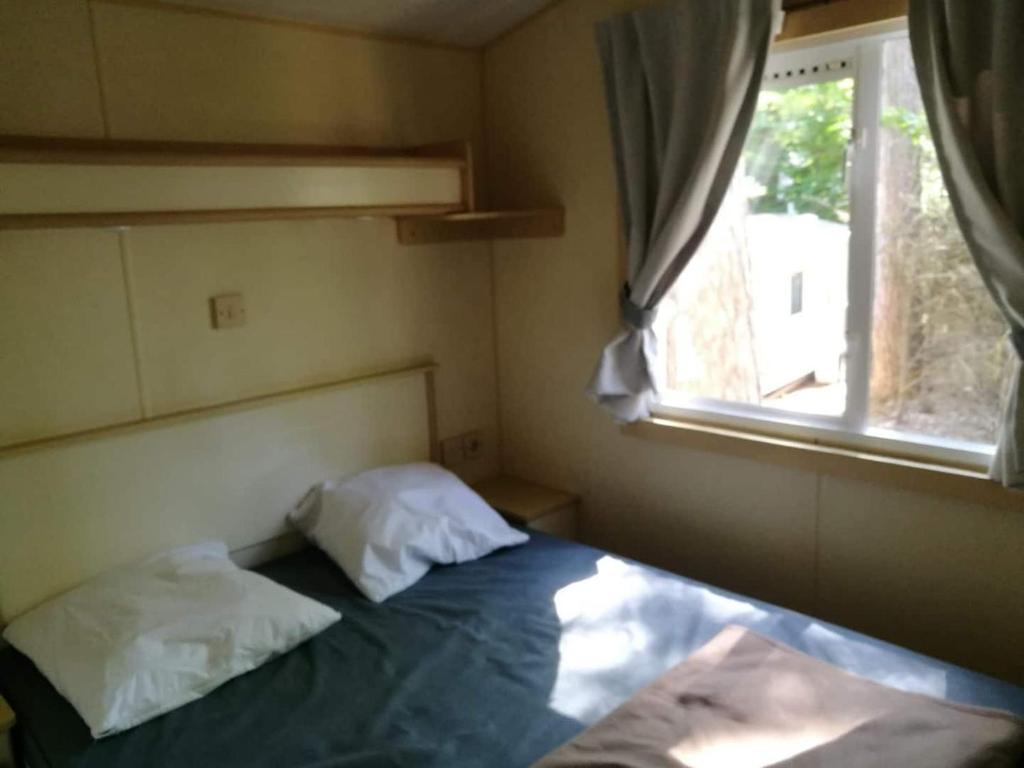 une petite chambre avec un lit et une fenêtre dans l'établissement 45mn de Paris Sympathique logement trois chambres - A76, à Saint-Chéron