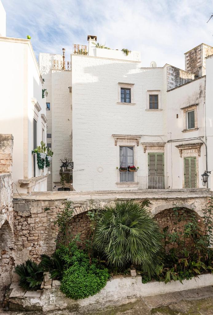 un bâtiment blanc avec des plantes devant lui dans l'établissement Torretta Martina, à Martina Franca 87 autres photos
