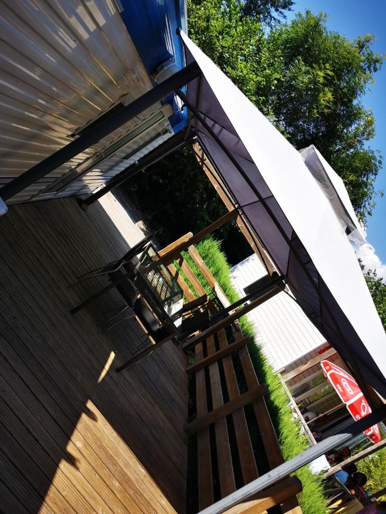 un parasol sur le côté d'une maison dans l'établissement Bungalow camping 3 étoiles, à Chazelles-sur-Lyon