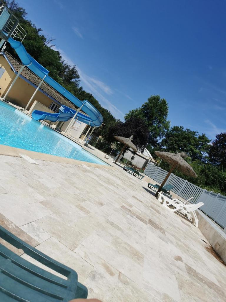 - une piscine avec 2 chaises et un toboggan dans l'établissement Bungalow camping 3 étoiles, à Chazelles-sur-Lyon