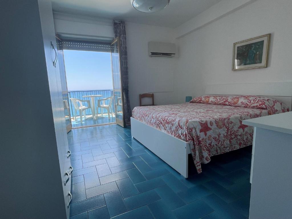 une chambre avec un lit et une vue sur l'océan dans l'établissement Hotel Ristorante Mareblu, à Amantea