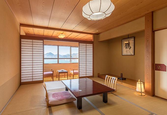 une chambre avec une table et une salle à manger avec vue dans l'établissement Hotel Yamadaya, à Shimoda