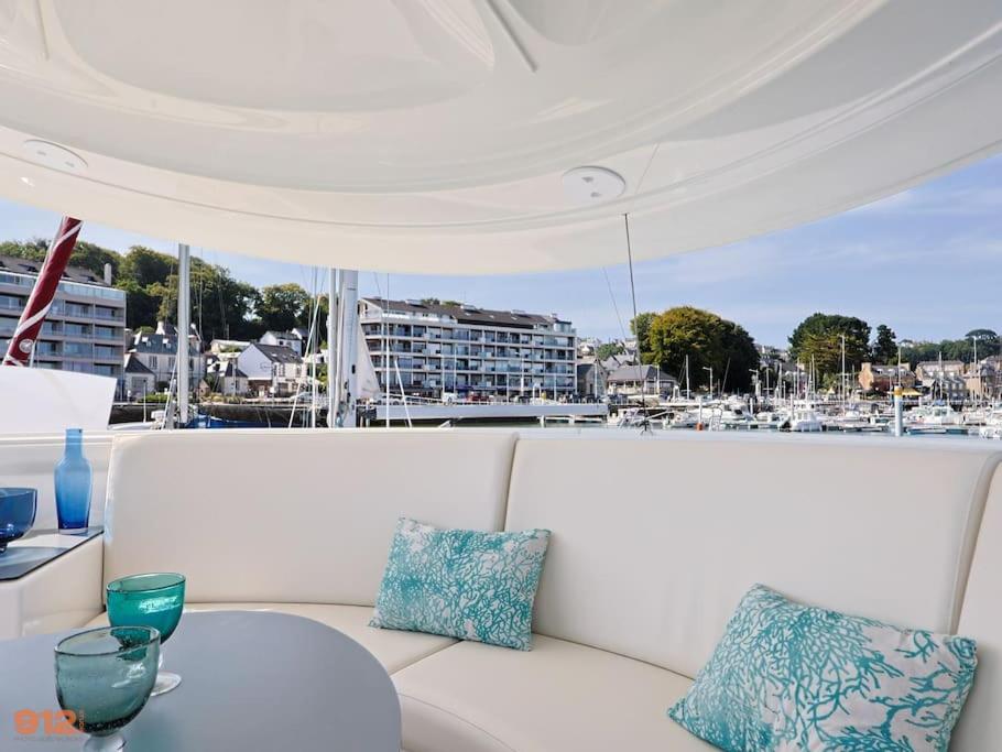 - un canapé blanc avec une table sur un bateau dans l'établissement ANTHENEA Suite Hôtelière Flottante, à Perros-Guirec