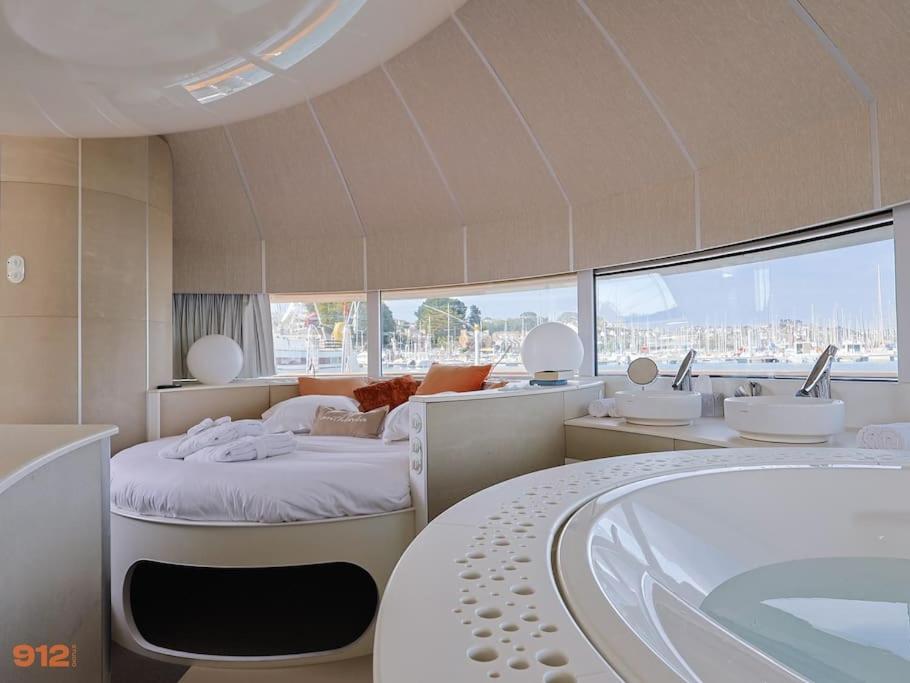 La salle de bains est pourvue d'une baignoire, d'un lit et d'une baignoire. dans l'établissement ANTHENEA Suite Hôtelière Flottante, à Perros-Guirec
