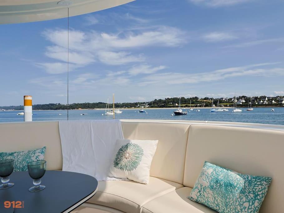 - un canapé avec une table et une vue sur l'eau dans l'établissement ANTHENEA Suite Hôtelière Flottante, à Perros-Guirec