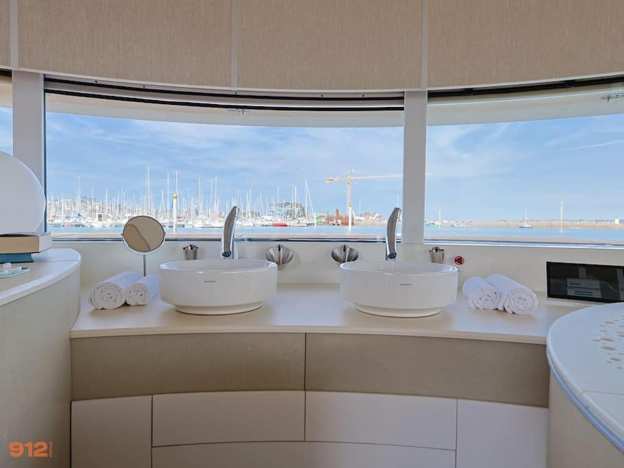 La salle de bains est pourvue de 2 lavabos et d'une grande fenêtre. dans l'établissement ANTHENEA Suite Hôtelière Flottante, à Perros-Guirec