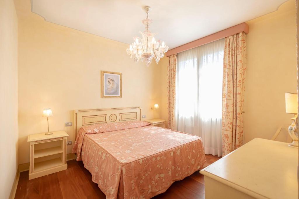 une chambre avec un lit et un lustre dans l'établissement Villa La Rosa dei Venti, à Fiorino