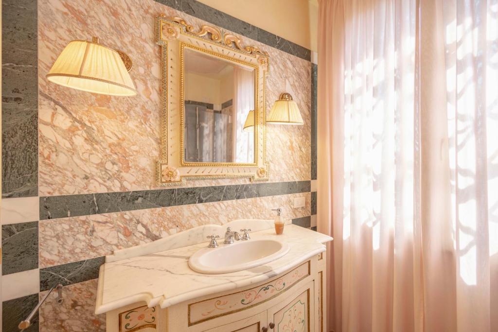 une salle de bain avec un lavabo et un miroir dans l'établissement Villa La Rosa dei Venti, à Fiorino